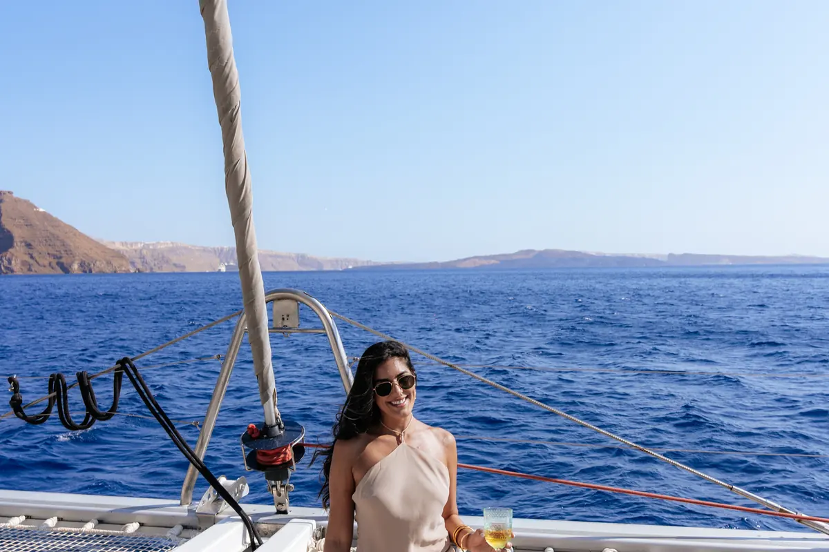 At the bow rail as the catamaran crosses the caldera's deep blue