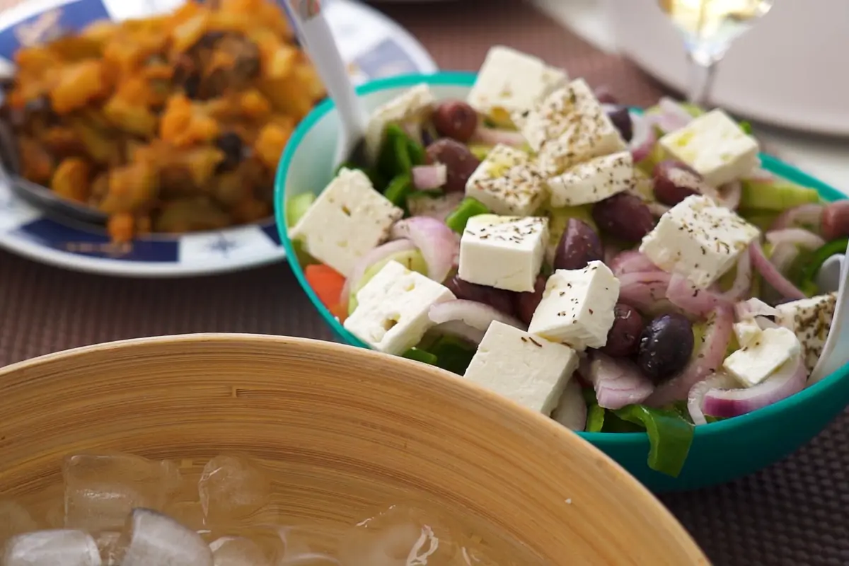 Greek salad with Santorini cherry tomatoes served on board