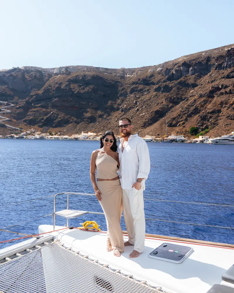 Standing on the bow trampolines beneath the caldera cliffs