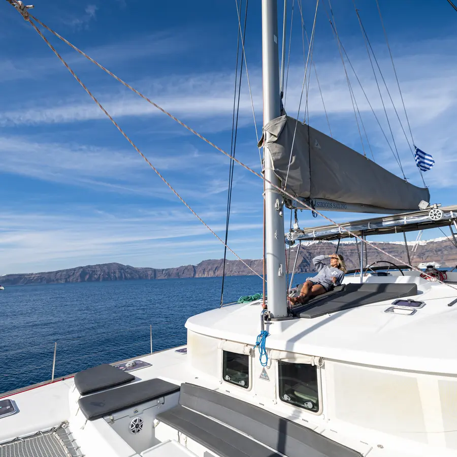 The jib set against a clear sky as the catamaran crosses the caldera
