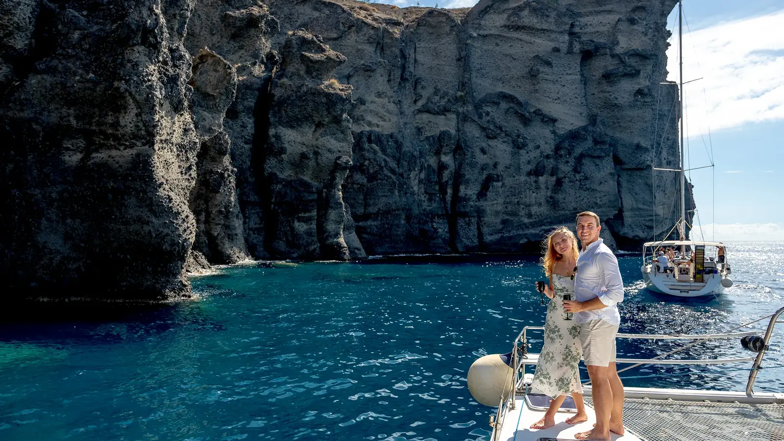 Private catamaran charter in Santorini — one boat alone on golden-hour water